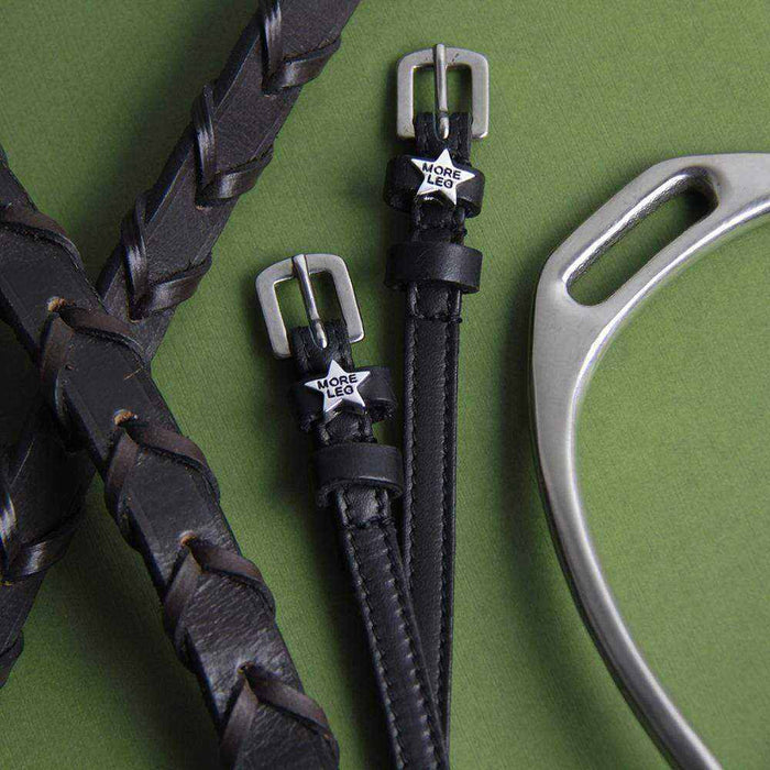 MORE LEG star spur straps with a braided leather rein and silver spur on green