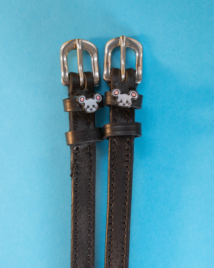 Black leather mouse charm spur straps with silver buckles on a light blue background