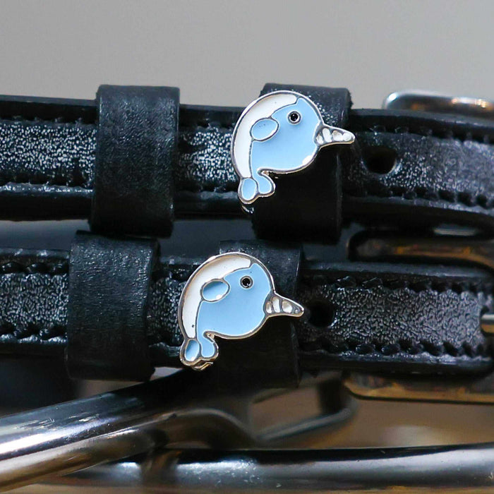 Close-up of two blue enamel narwhal charms on black leather ManeJane spur strap keepers