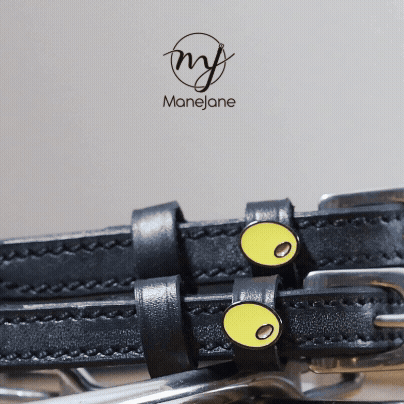 ManeJane branded close-up of olive charms on black leather spur straps with logo