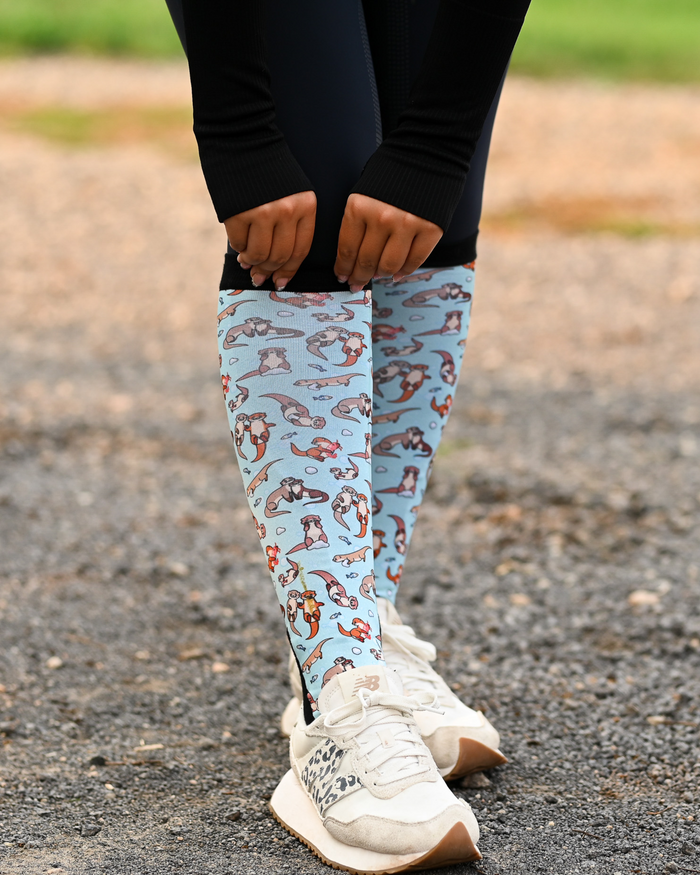 Otter-ly Adorable Pair & a Spare boot socks worn on the calf, pale blue with otters floating and holding hands