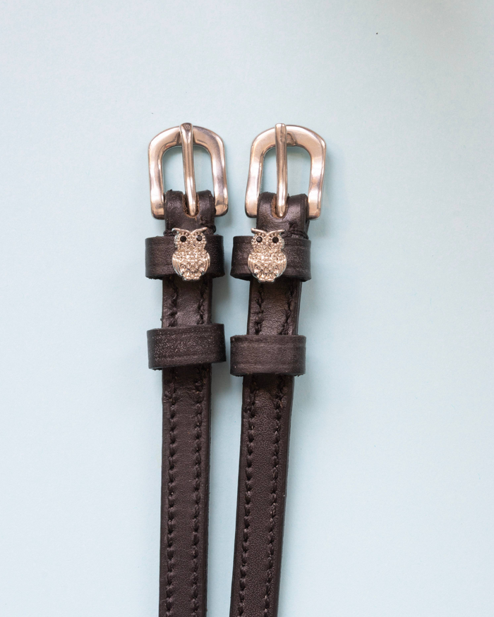 Dark brown leather ManeJane owl charm spur straps with silver buckles on pale mint