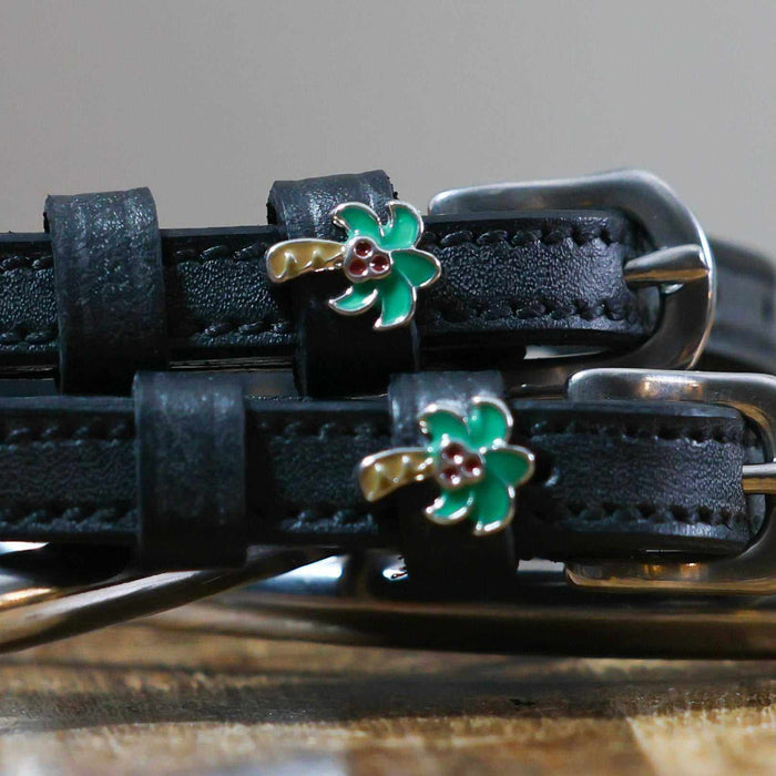 Close-up of enamel palm tree charms on black leather spur strap keepers