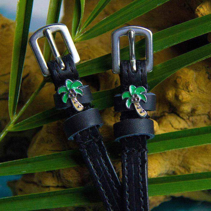 Palm tree spur straps styled among tropical palm fronds and driftwood
