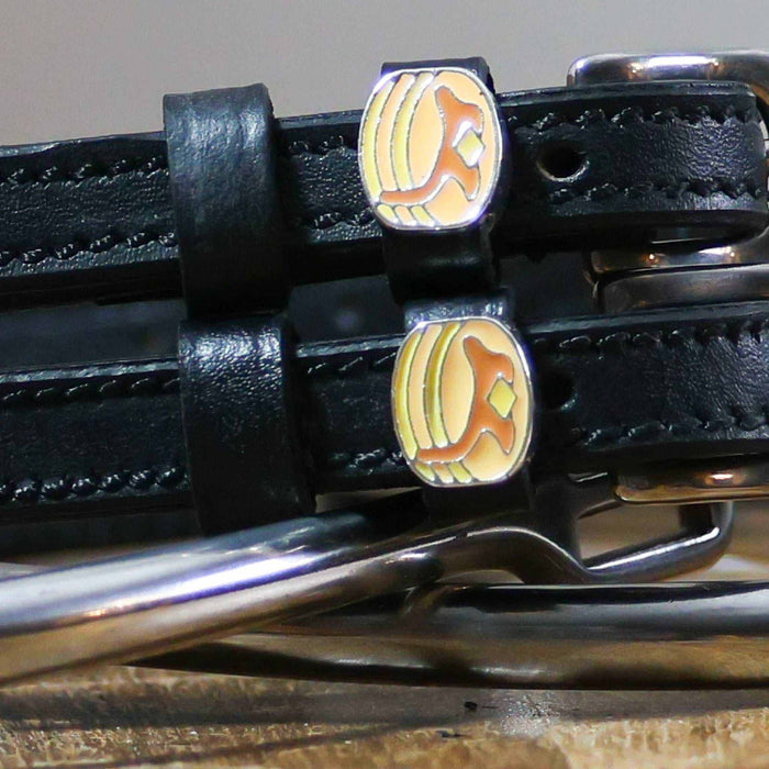 Close-up of enamel pancake stack charms on black leather ManeJane spur strap keepers
