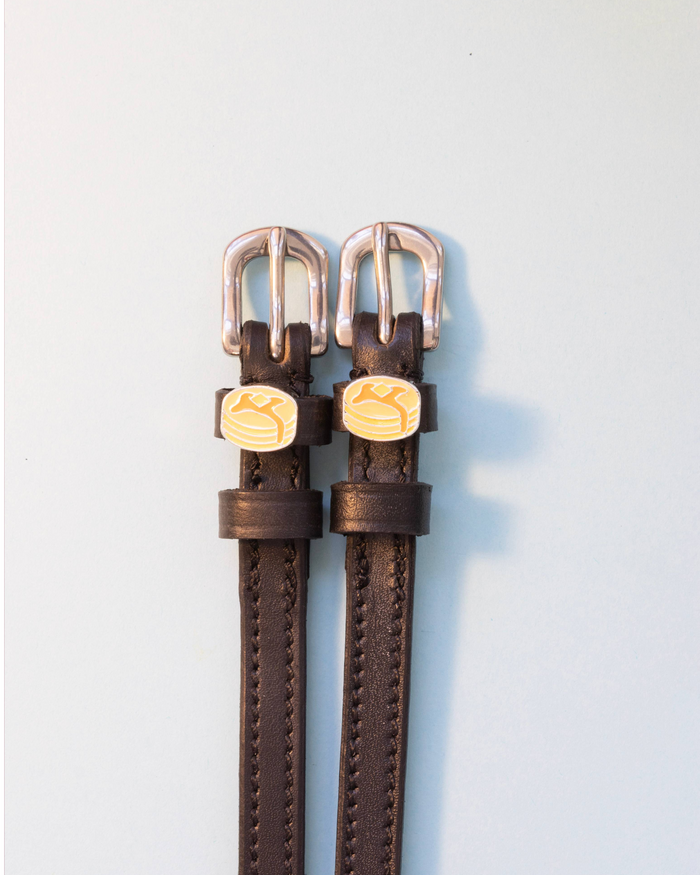 Brown leather ManeJane spur straps with silver buckles and pancake charms