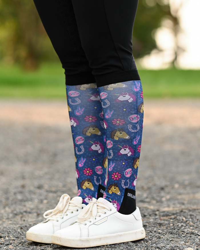 Patch Perfect riding boot socks styled over breeches, navy with unicorn, horseshoe and daisy patch badges