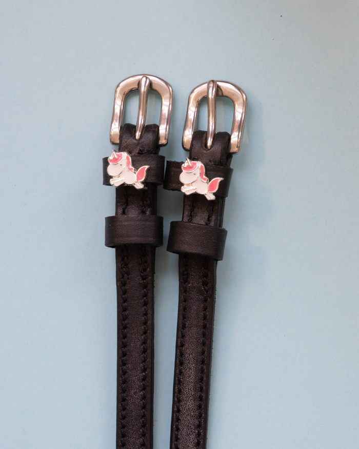 Brown leather Phat Unicorn spur straps with rose-gold buckles and charms
