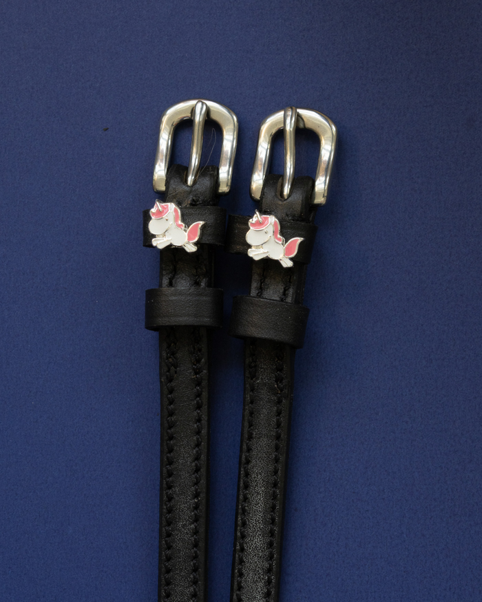 ManeJane chubby unicorn spur straps with silver buckles laid flat on navy blue