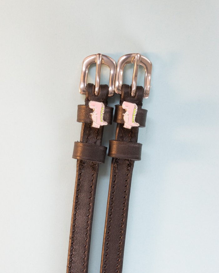 Brown leather pink dinosaur spur straps with rose-gold buckles and T-rex charms