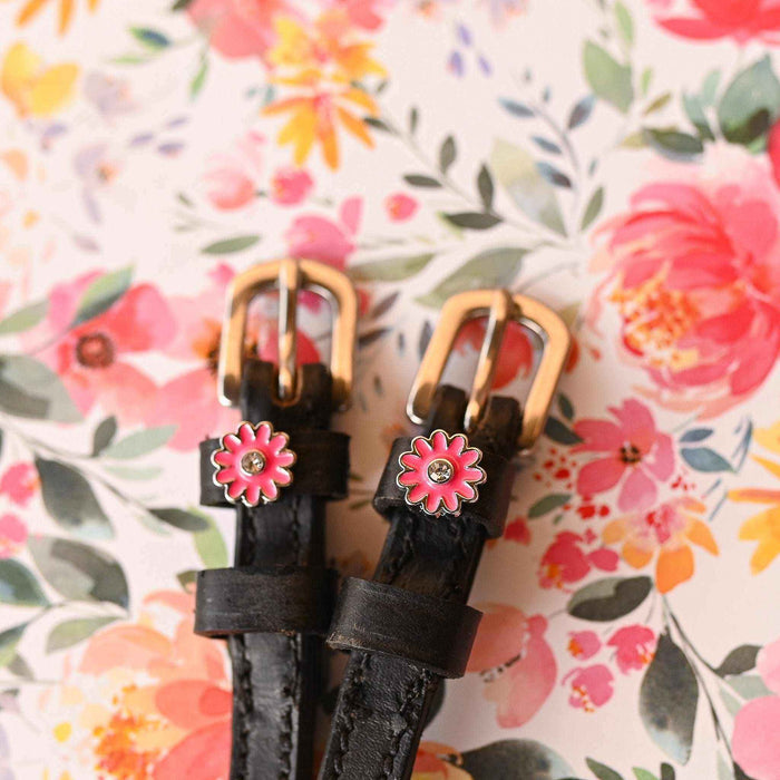 Pink flower spur strap gold buckle ends against a watercolor floral background