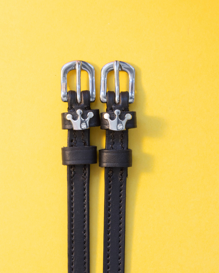 ManeJane Queenie crown spur straps with silver buckles on a yellow background