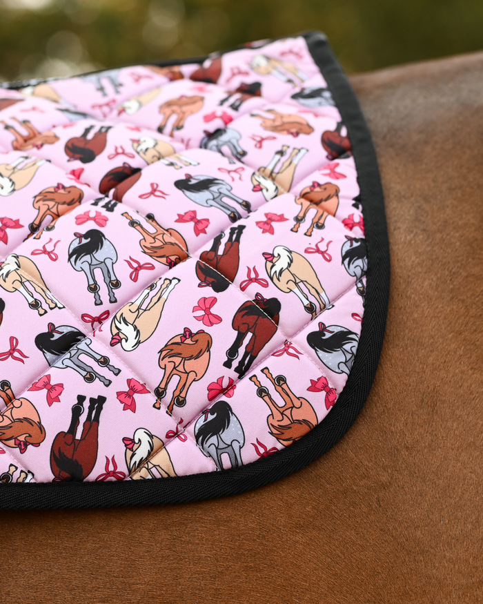 Close crop of the Red Ribbon Girlies print: rear-view mares with red tail bows on pale pink quilting