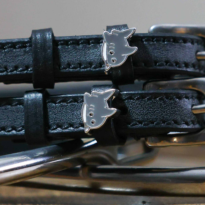 Close-up of silver shark charms on black leather spur strap keepers with hardware