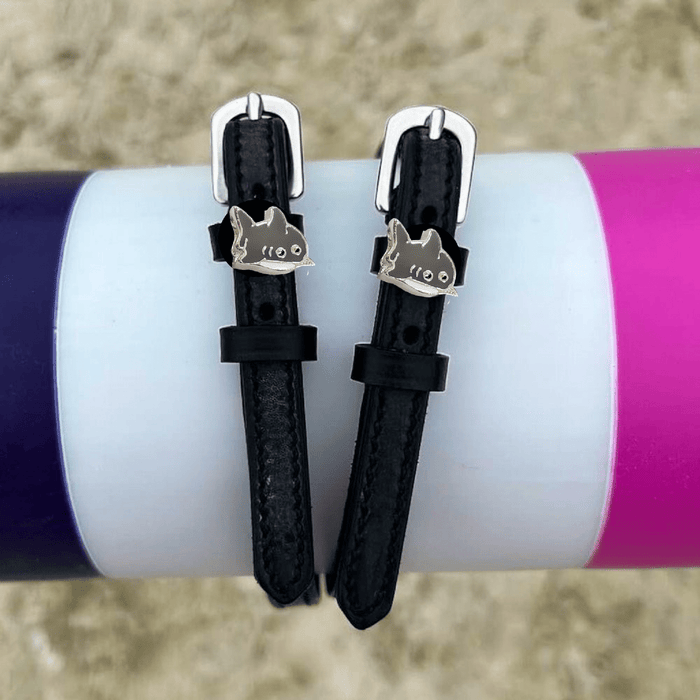 Black shark spur straps wrapped around a colorful tumbler outdoors, lifestyle shot