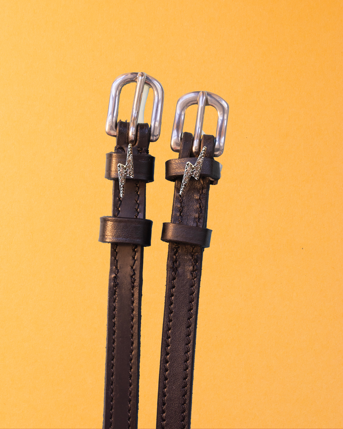 Brown leather ManeJane bolt charm spur straps with silver buckles on golden yellow