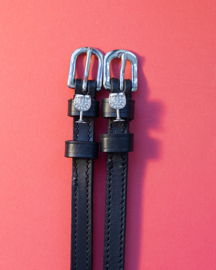 Black leather ManeJane spur straps with crystal-set silver wine glass charms on coral red