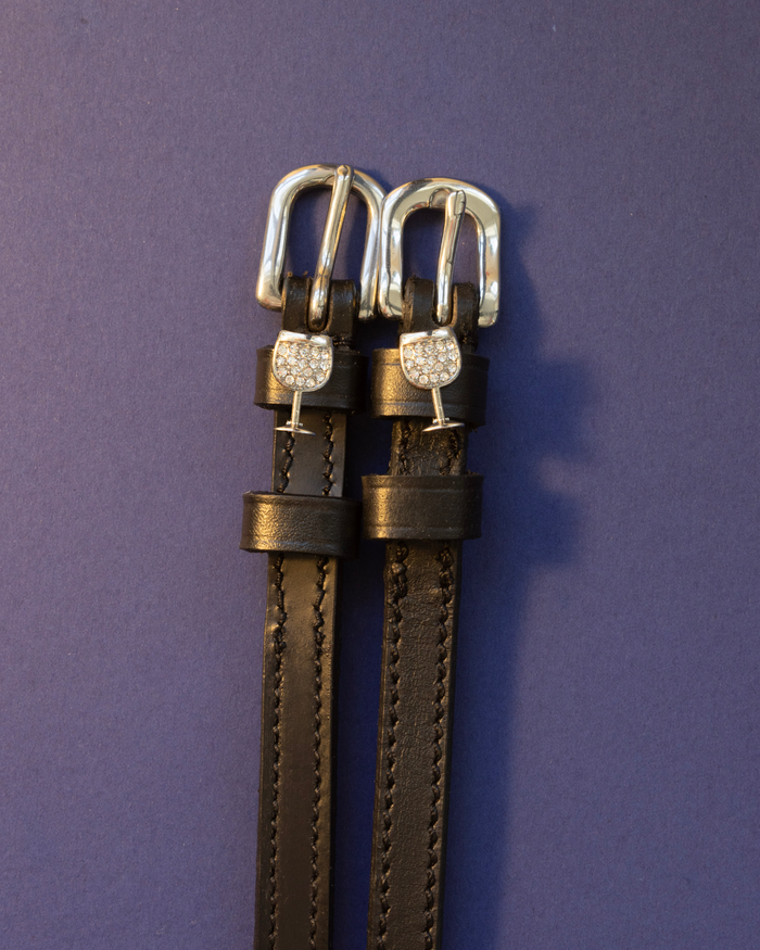 Pair of black leather crystal wine glass spur straps with silver buckles on purple