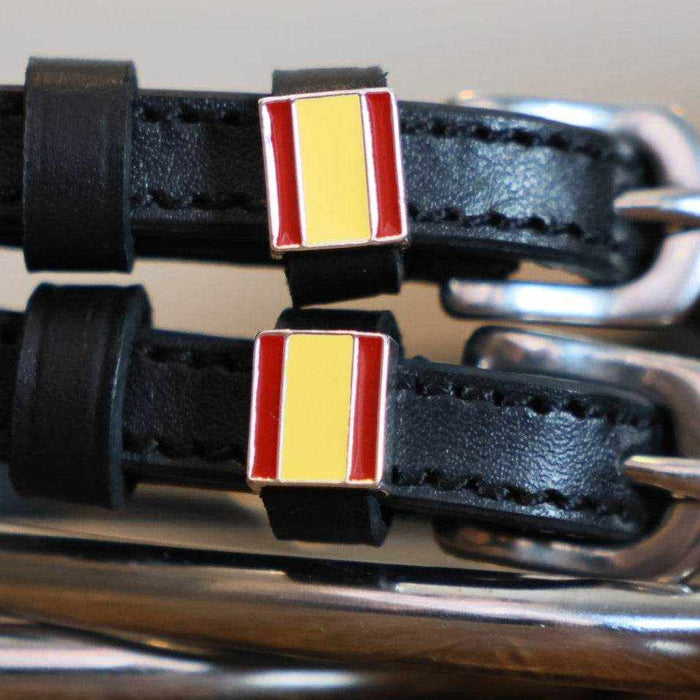 Close-up of Spain flag charms on black leather ManeJane spur strap keepers