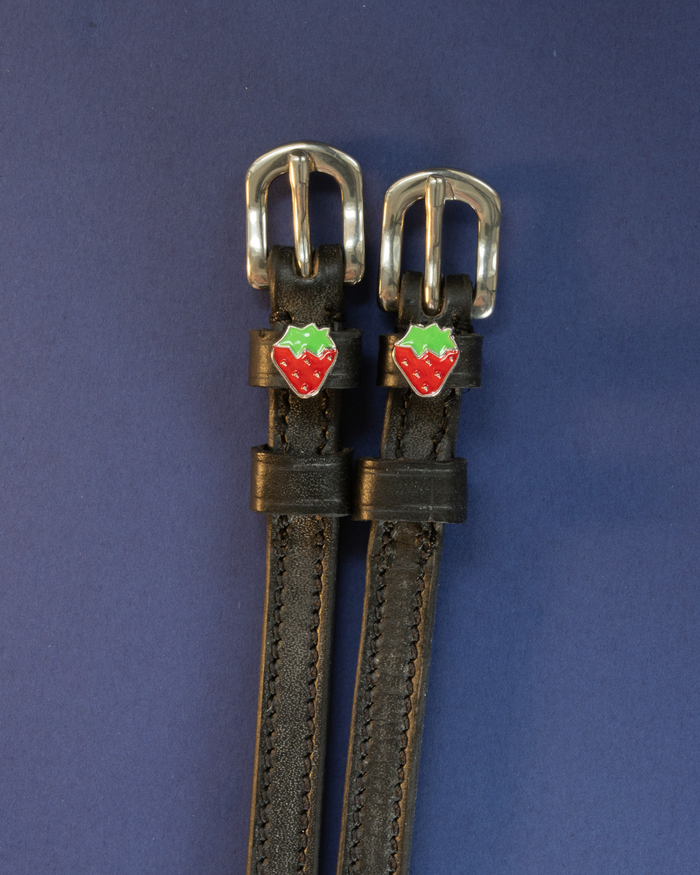 ManeJane strawberry spur straps with red-and-green strawberry charms on a navy background