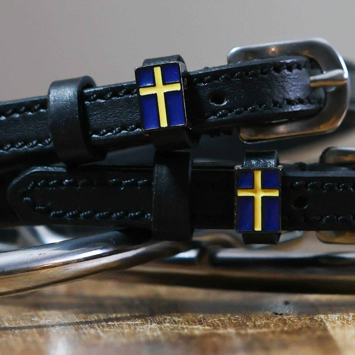 Close-up of a blue-and-yellow Swedish flag charm on a black leather spur strap