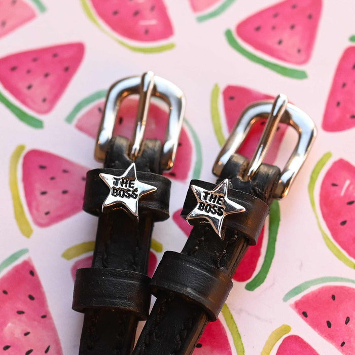 Close-up of 'The Boss' silver star charms on ManeJane spur straps over a watermelon print