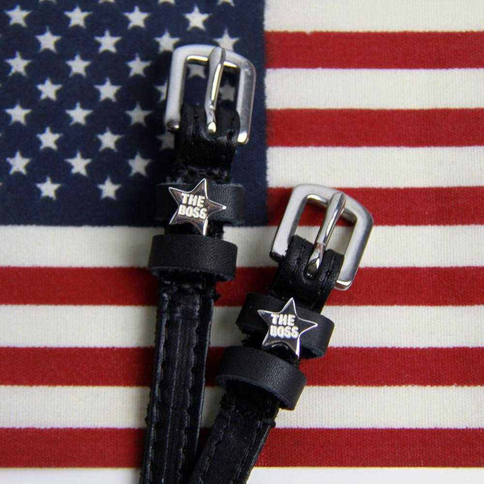 Black leather Boss star spur straps displayed on an American flag background