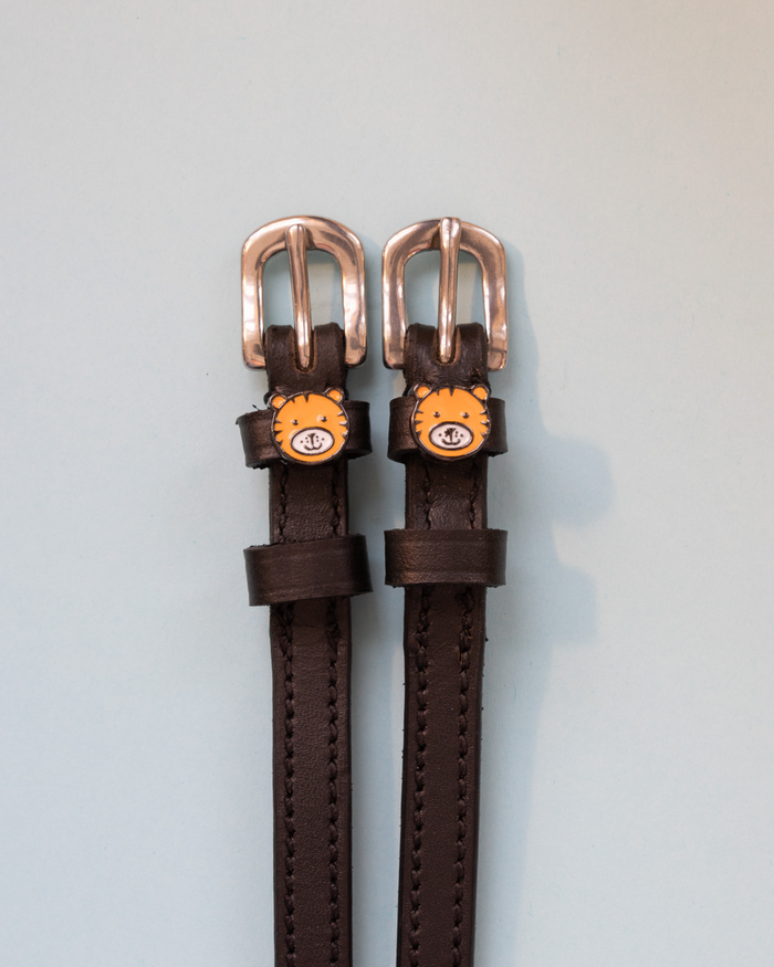 Brown leather tiger spur straps with rose-gold buckles and tiger-face charms
