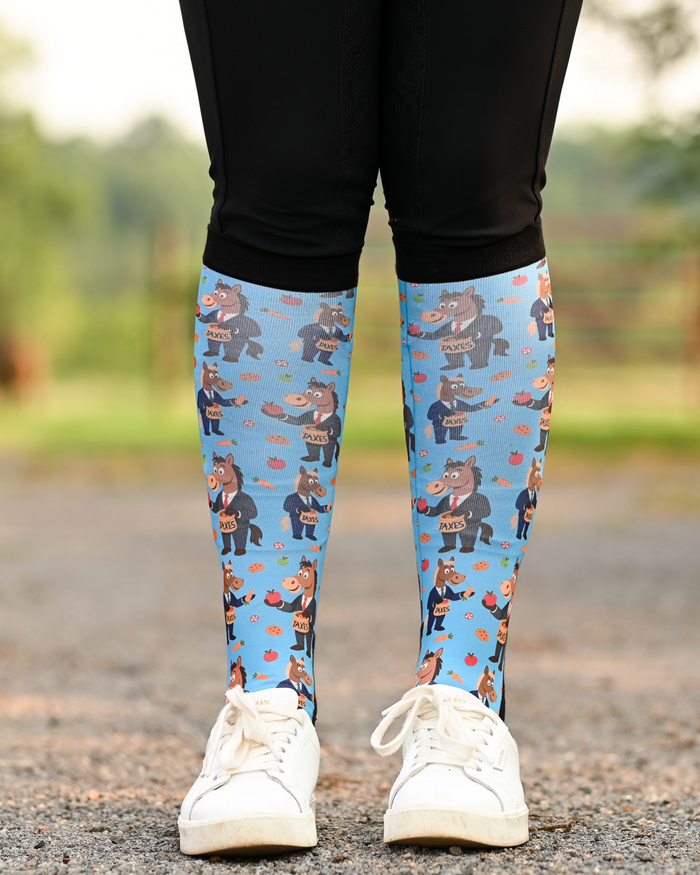 Treat Tax boot socks seen from the front, bright blue ground scattered with horses in business suits paying the treat tax
