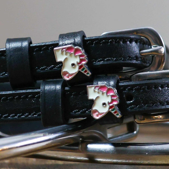 Close-up of enamel unicorn head charms on black leather ManeJane spur strap keepers