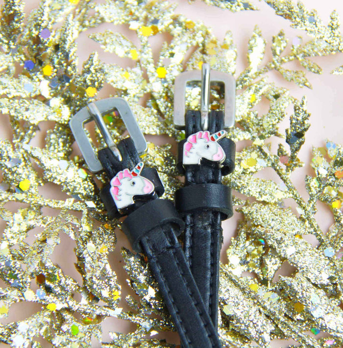 Unicorn charm spur strap buckle ends styled on gold glitter foliage