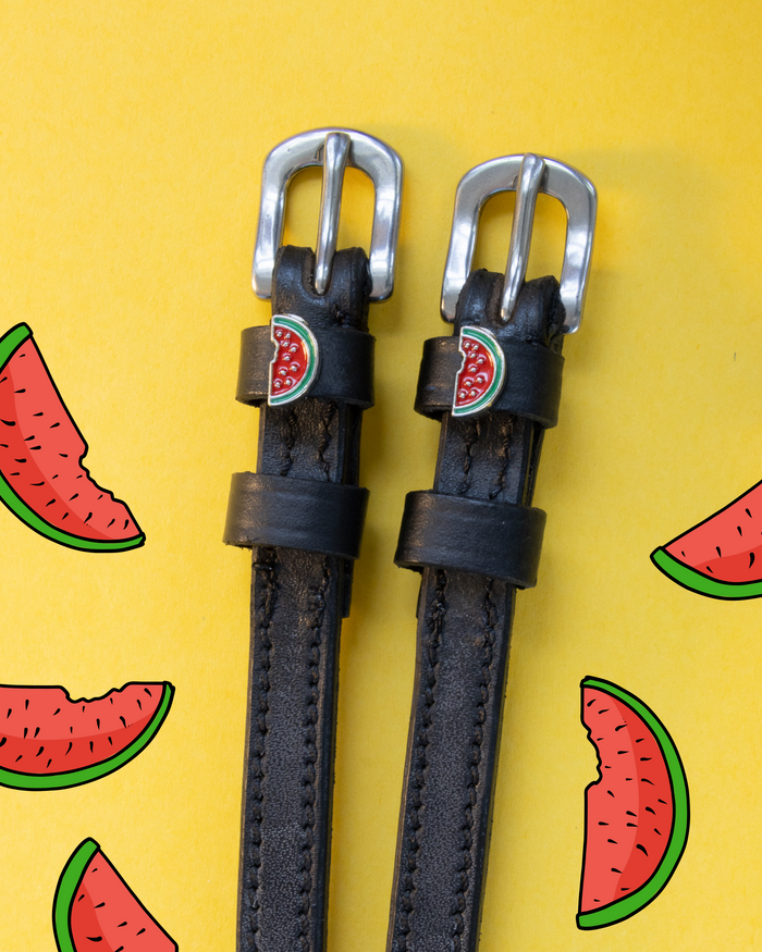 Black leather ManeJane watermelon spur straps on yellow with watermelon-slice illustrations